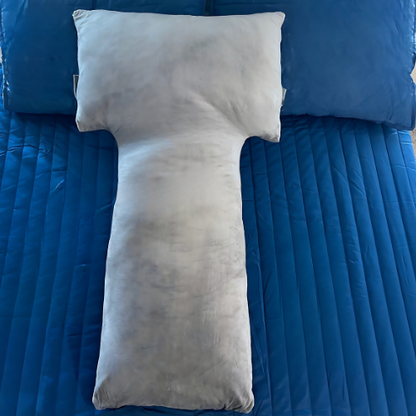 This image showcases the Special T Pillow laid out on a blue bedspread, emphasizing its distinctive T-shape. The pillow's grey velvet cover and ergonomic design are highlighted, illustrating its appeal for providing targeted support and enhancing sleep comfort.